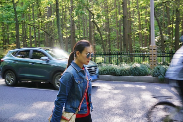 A person test driving a car, looking focused and attentive while driving on a suburban road. The salesperson is in the passenger seat, and the scenery includes houses and trees.