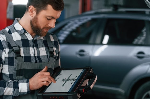 A mechanic using a professional diagnostic tool to check the electronic systems of a car in a garage.
