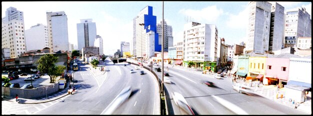 A split image showing two distinct scenarios: on the left side, a bustling city street with numerous electric vehicles and charging stations; on the right side, a rural highway with predominantly traditional gasoline-powered vehicles. The image contrasts future possibilities with current realities.