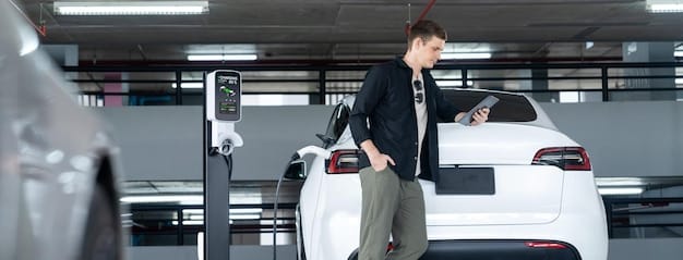 A row of modern EV charging stations at a car dealership, with various electric vehicles connected and charging. A technician in uniform is inspecting one of the charging stations.