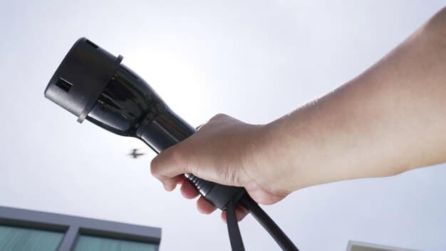 A close-up shot of an EV charging station connector being plugged into an electric vehicle. The focus is on the connector and the charging port, highlighting the ease and user-friendliness of the charging process. The EV is a modern sedan with a sleek design, parked at a charging station with clear signage. The background is slightly blurred to keep the attention on the charging action.