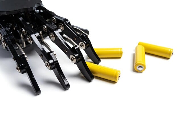 A close-up shot of a robotic arm precisely assembling a battery pack for an electric vehicle. The background shows a clean, high-tech manufacturing environment with other automated processes. The image emphasizes the precision and technological complexity of EV battery production.