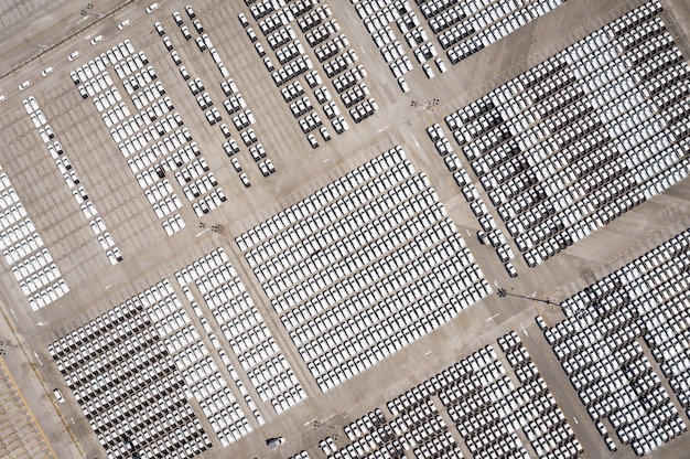 An aerial view of a large battery manufacturing plant, showing the scale of the operation and the numerous employees working inside. Solar panels are visible on the roof, highlighting the sustainability aspect.