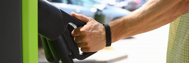 A close-up shot of a modern electric vehicle charging at a public charging station with a visible digital display showing the charging progress. The focus is on the charging port and cable connection, highlighting the accessibility and convenience of EV charging infrastructure.
