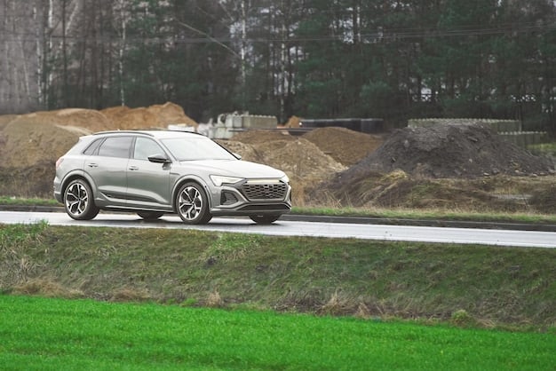 A side profile of the 2025 Audi Q5 in motion on a winding coastal road. The car is painted deep blue, contrasting with the bright sky and ocean. The image conveys a sense of freedom, adventure, and the joy of driving.