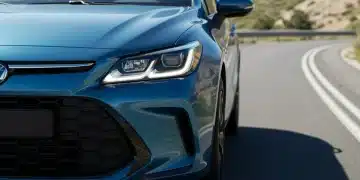 Sleek metallic blue 2025 Hybrid Hatchback front view on a winding road.